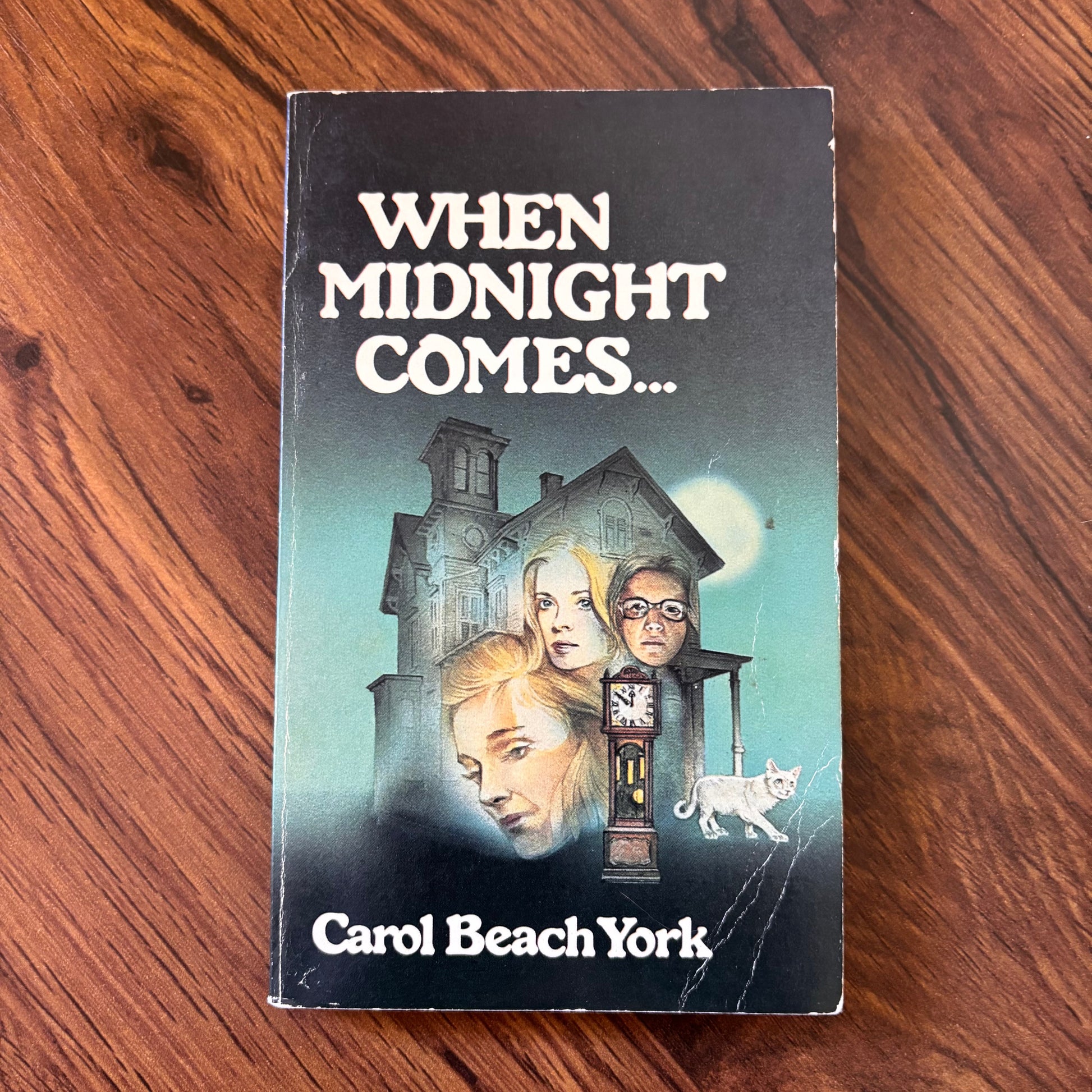 Cover of “When Midnight Comes” by Carol Beach York, 1979 Scholastic paperback edition, showing an eerie midnight scene with a spectral figure and an old house, typical of vintage horror novels.