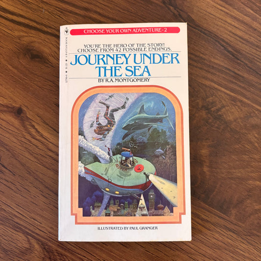 Journey Under the Sea by R.A. Montgomery, illustrated by Paul Granger. 1979 Bantam Choose Your Own Adventure Book #2. A vintage interactive paperback with 42 possible endings, deep-sea peril, and classic CYOA nostalgia. A must-have for retro book collectors. omgihadthat.com