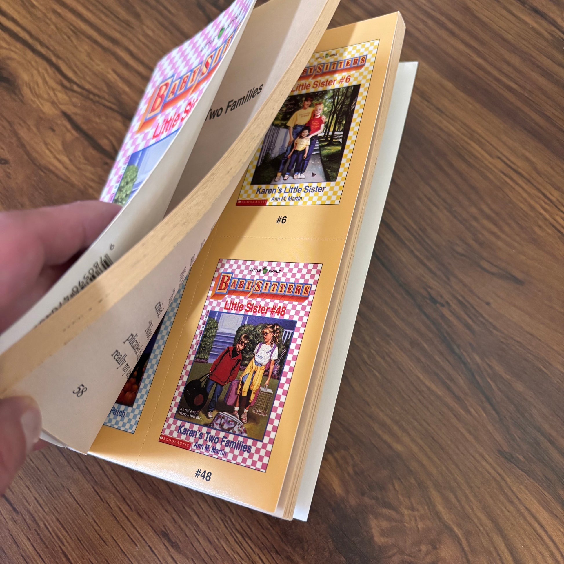 Karen’s Two Families by Ann M. Martin, a vintage Baby-Sitters Little Sister paperback about Karen trying to split her time between Mommy and Daddy, with original bonus cards still inside.