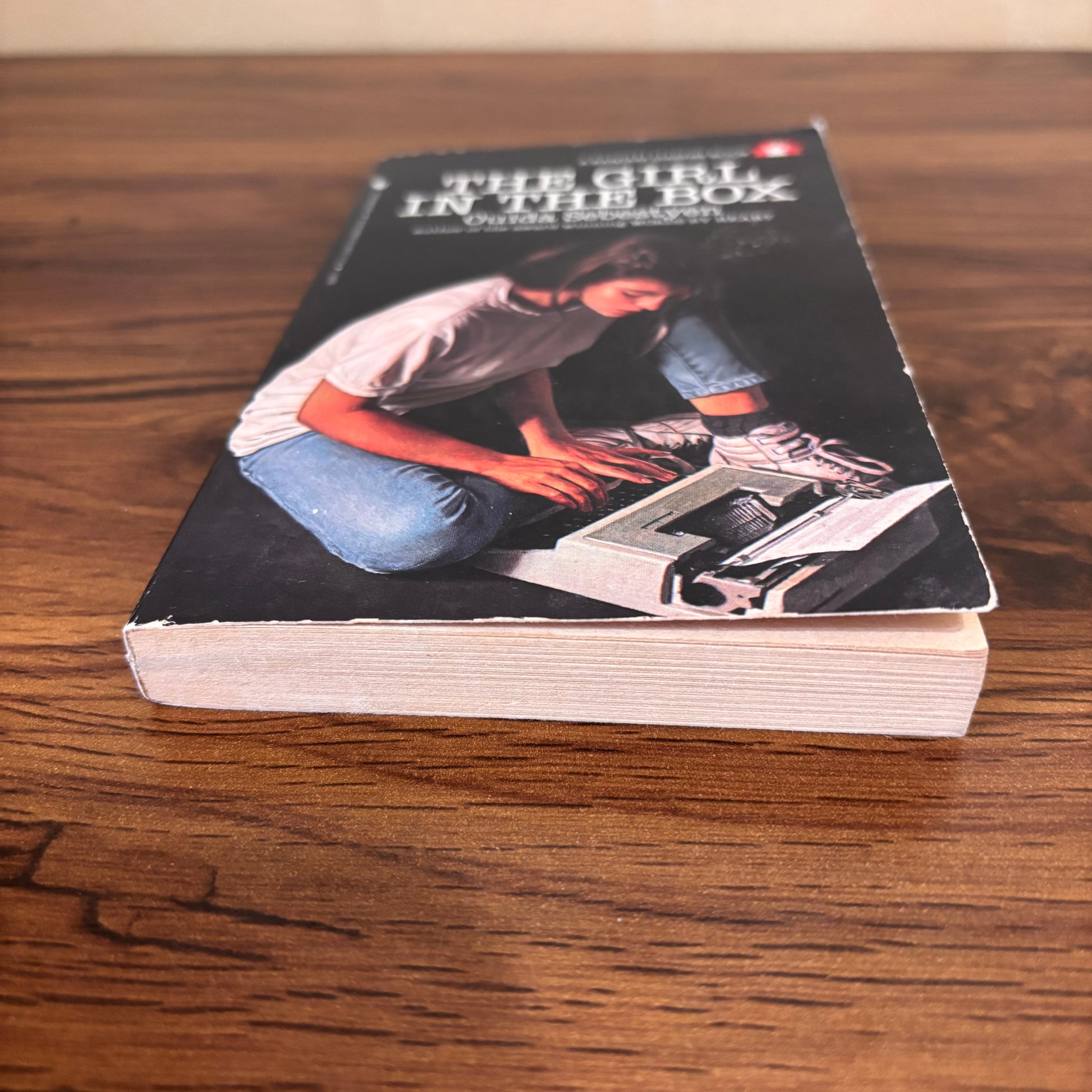 Old YA fiction paperback The Girl in the Box, a survival story where Jackie McGee uses a typewriter to tell anyone out there what happened before it is too late.