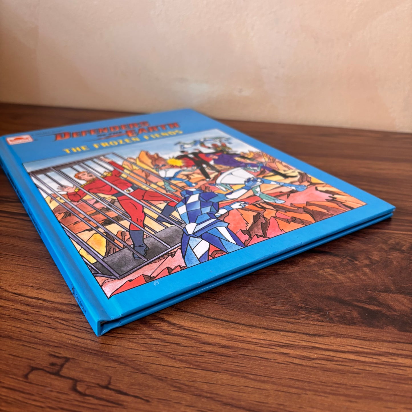 Retro superhero kids book Defenders of the Earth, featuring The Frozen Fiends cover with heroes, villains, icy action scenes, and classic 1980s animated series energy.