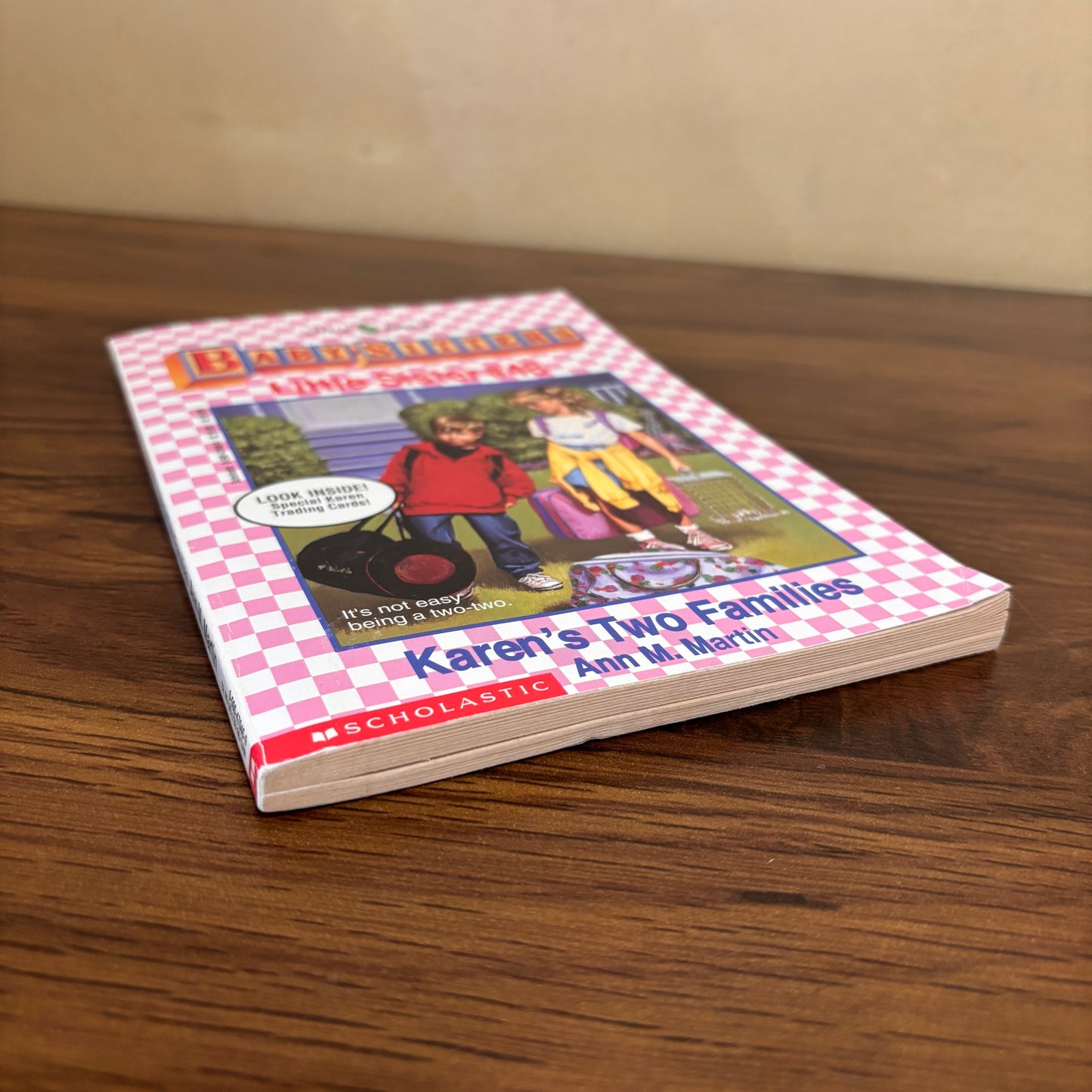 Scholastic Baby-Sitters Little Sister Karen’s Two Families by Ann M. Martin, a retro girls chapter book with trading cards still inside, centered on Karen navigating life between her mom’s house and dad’s house.