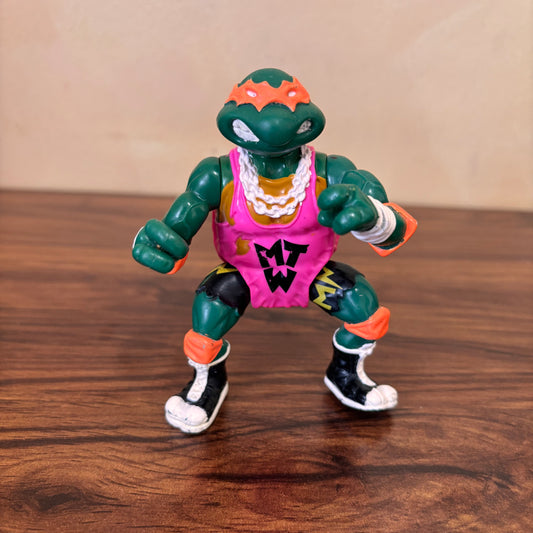 Shell Slammin Michelangelo 1991 TMNT action figure by Playmates. Retro collectible with wrestling action, perfect for vintage toy collectors and Teenage Mutant Ninja Turtles fans!