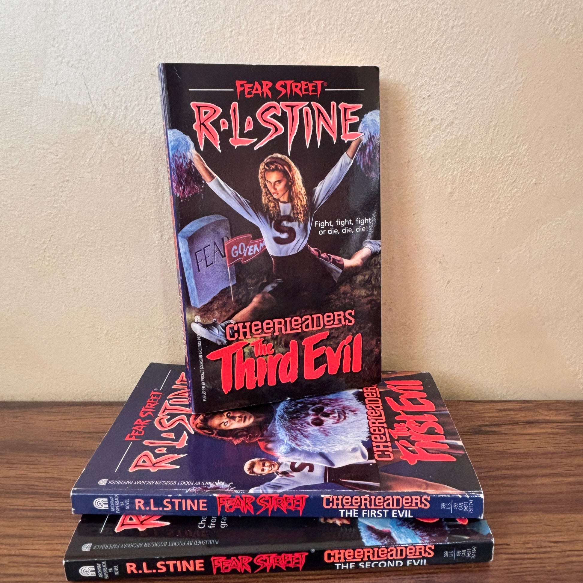 Vintage YA horror book set featuring R.L. Stine’s Fear Street Cheerleaders trilogy, with The First Evil, The Second Evil, and The Third Evil paperbacks for retro horror fiction fans.